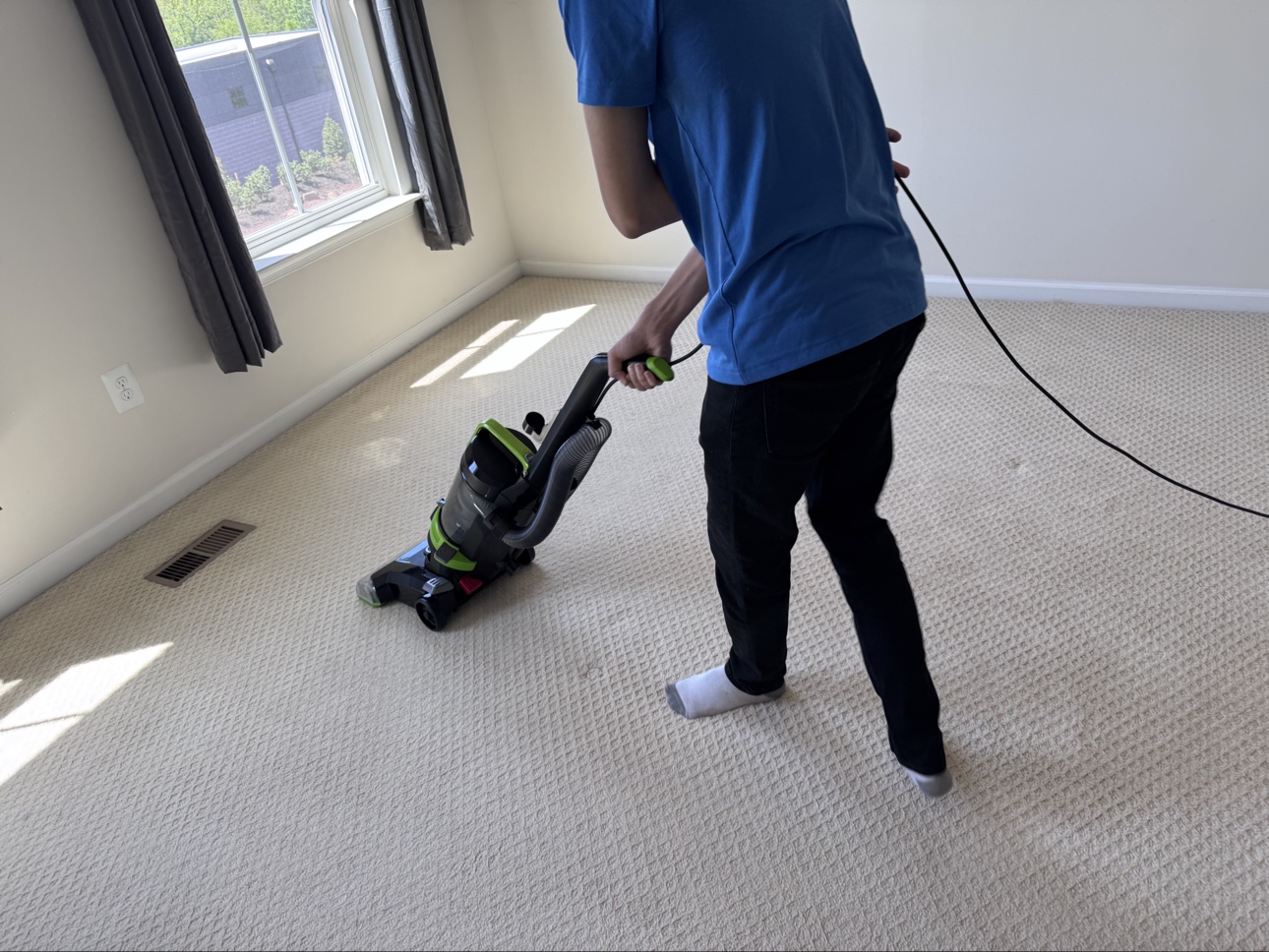 Clean Squad team member deep cleaning carpet with professional equipment
